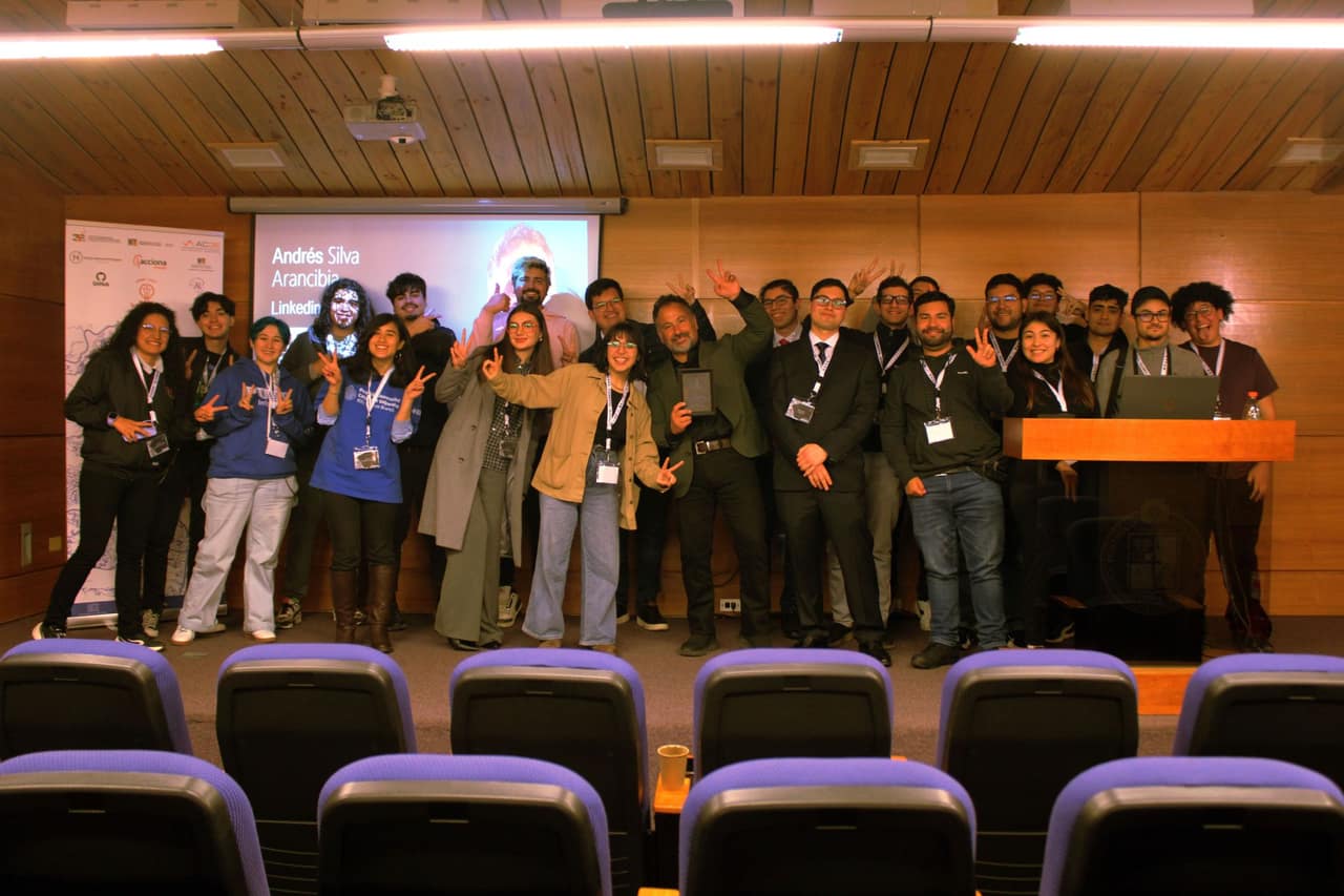 Asistentes de distintas ramas IEEE posando en el auditorio durante la Reunión Nacional de Ramas, con una charla proyectada al fondo